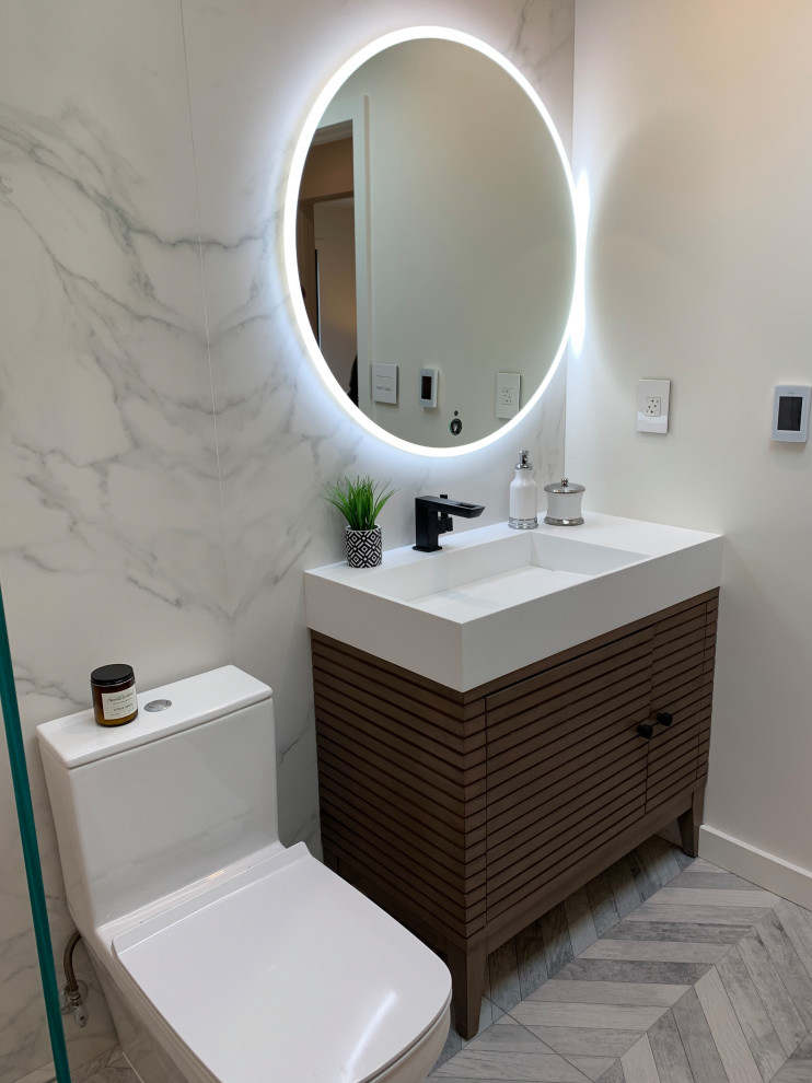This is an example of a large contemporary master wet room bathroom with louvered cabinets, dark wood cabinets, a freestanding tub, a one-piece toilet, white tile, marble, white walls, marble floors, an integrated sink, grey floor, a hinged shower door, white benchtops, a niche, a single vanity and a freestanding vanity.