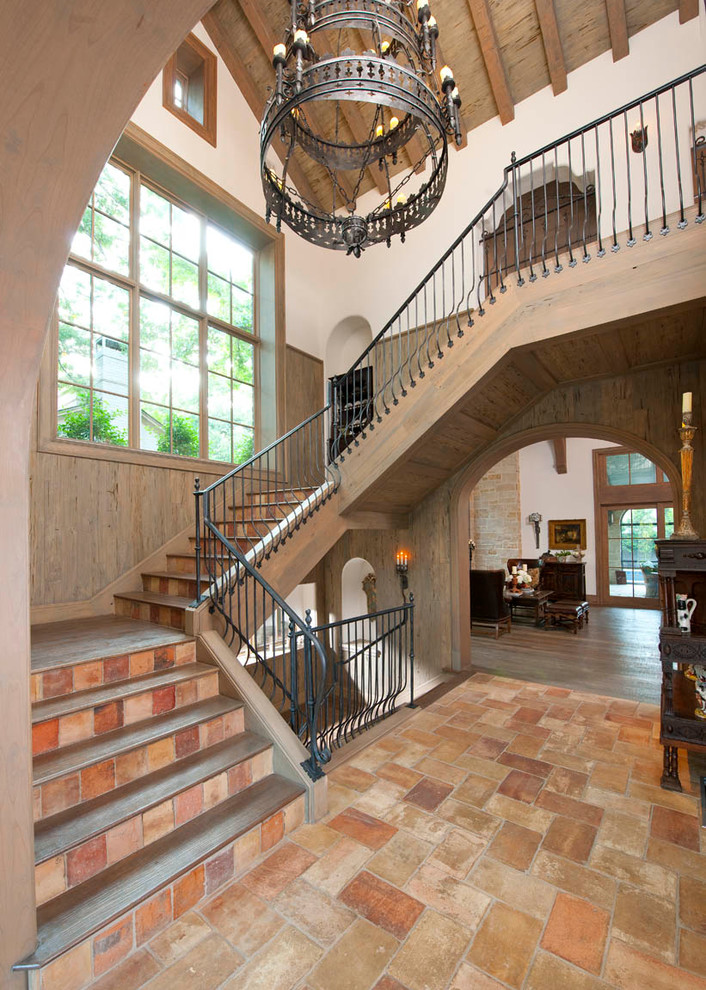 Design ideas for a mediterranean wood staircase in Dallas with terracotta risers and metal railing.