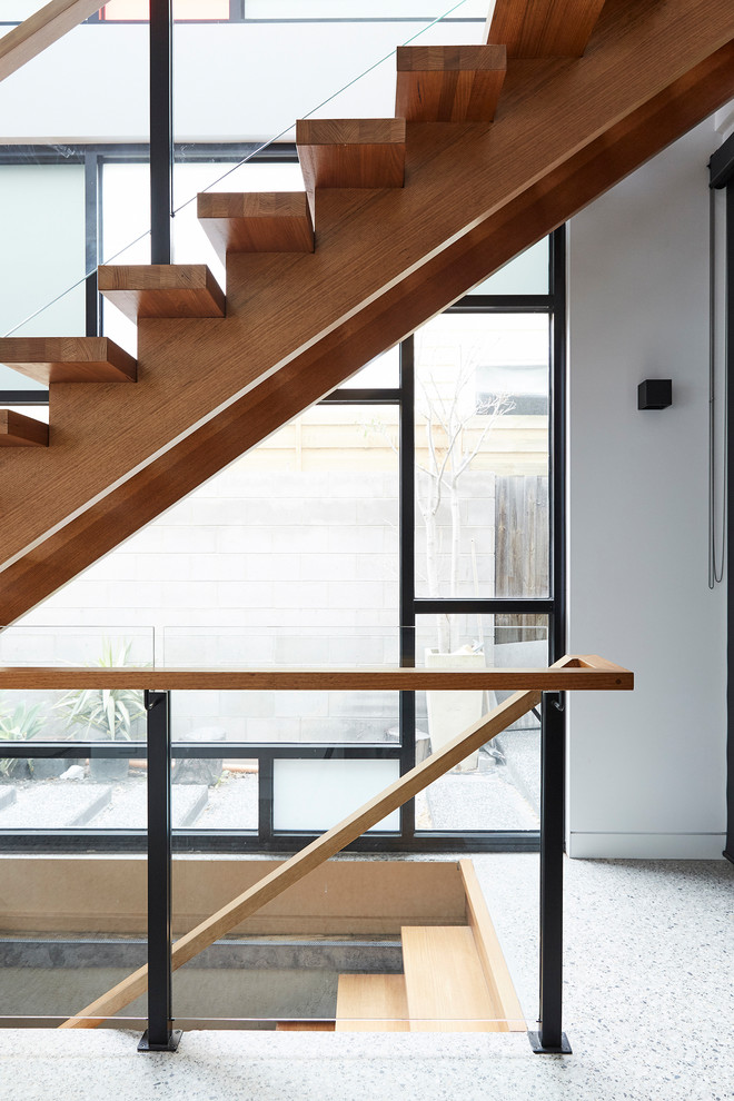 Photo of a mid-sized contemporary wood straight staircase in Melbourne with open risers and wood railing.