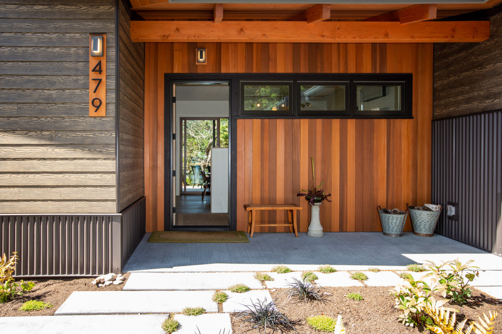 Inspiration for a mid-sized midcentury front door in Seattle with multi-coloured walls, medium hardwood floors, a single front door, a black front door, brown floor and exposed beam.