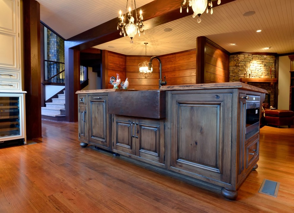 Example of a mid-sized transitional u-shaped medium tone wood floor eat-in kitchen design with an undermount sink, raised-panel cabinets, white cabinets, marble countertops, white backsplash, brick backsplash, paneled appliances and an island
