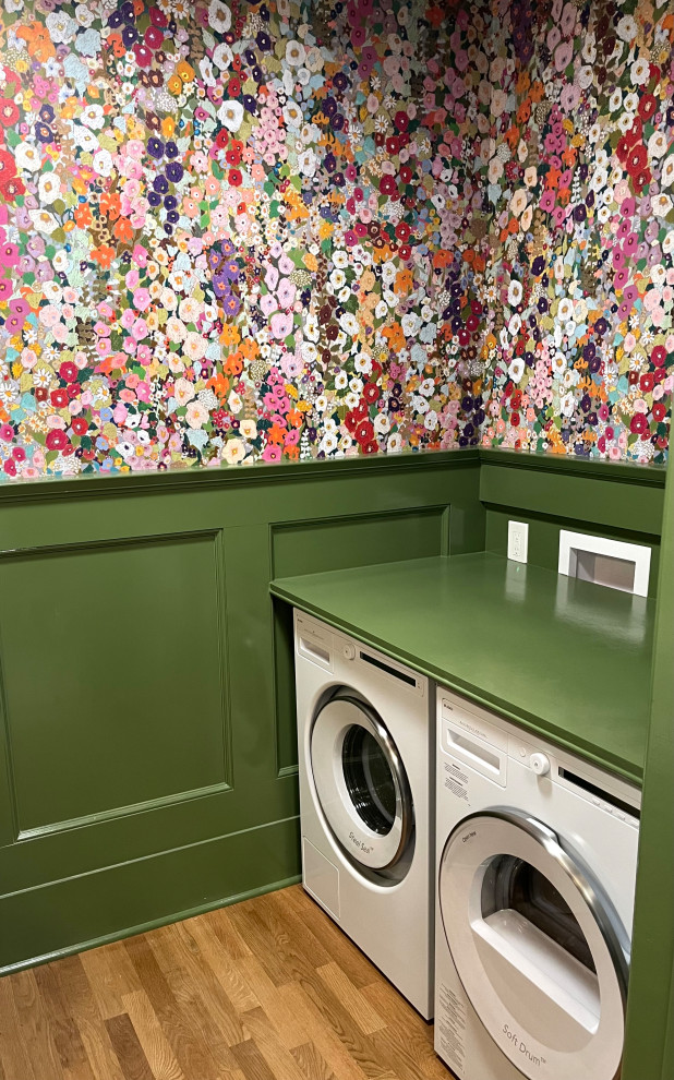 This is an example of a small bohemian galley utility room in New York with wood worktops, green splashback, wood splashback, multi-coloured walls, light hardwood flooring, a side by side washer and dryer, brown floors and green worktops.