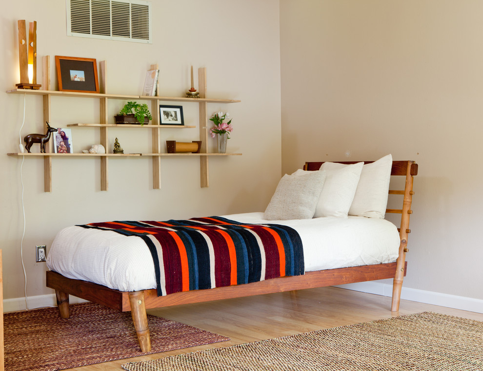 Photo of a mid-sized midcentury guest bedroom in Seattle with beige walls and light hardwood floors.