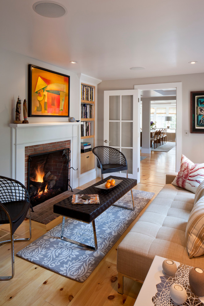 Mid-sized contemporary enclosed family room in Boston with grey walls, a library, light hardwood floors, a standard fireplace, a brick fireplace surround and brown floor.