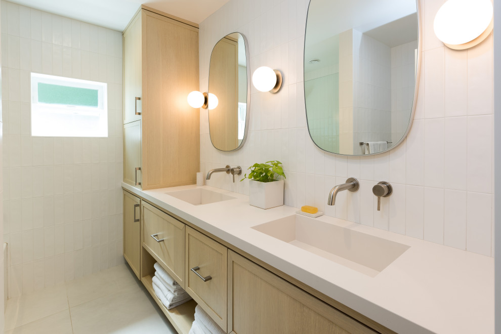Пример оригинального дизайна: маленькая главная ванная комната в морском стиле с фасадами в стиле шейкер, бежевыми фасадами, душем над ванной, унитазом-моноблоком, белой плиткой, керамической плиткой, белыми стенами, полом из керамогранита, монолитной раковиной, столешницей из искусственного кварца, белым полом, душем с распашными дверями, белой столешницей, тумбой под две раковины и подвесной тумбой для на участке и в саду