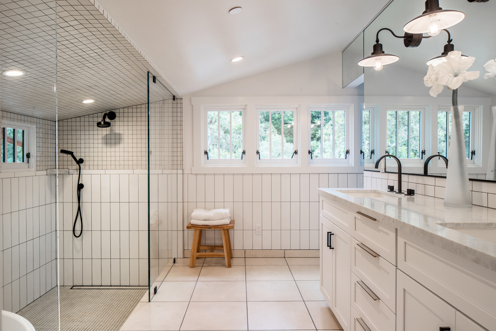 Photo of a large transitional master wet room bathroom in Other with shaker cabinets, white cabinets, white tile, ceramic tile, white walls, limestone floors, an undermount sink, marble benchtops, beige floor, an open shower, white benchtops, a double vanity, a built-in vanity and vaulted.