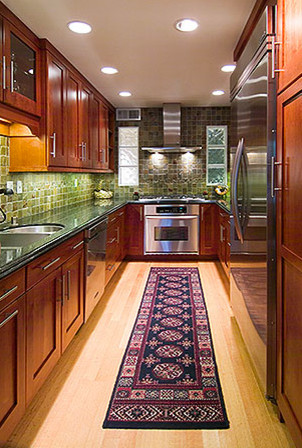 Example of a mid-sized trendy u-shaped enclosed kitchen design with a double-bowl sink, recessed-panel cabinets, dark wood cabinets, green backsplash, stainless steel appliances, granite countertops and no island