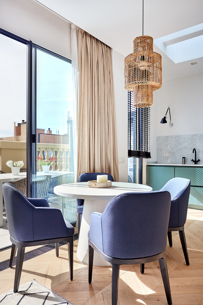 Modelo de comedor tradicional renovado abierto con paredes blancas, suelo de madera clara, suelo beige y cortinas