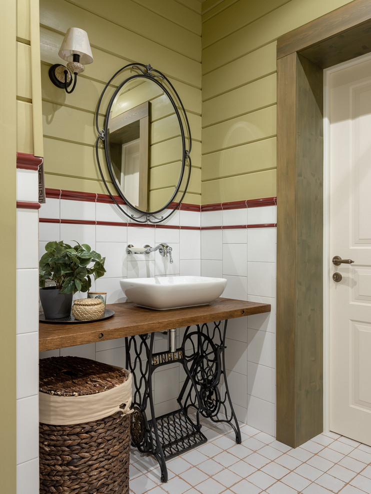 Photo of a country bathroom in Moscow with white tile, a vessel sink and brown benchtops.