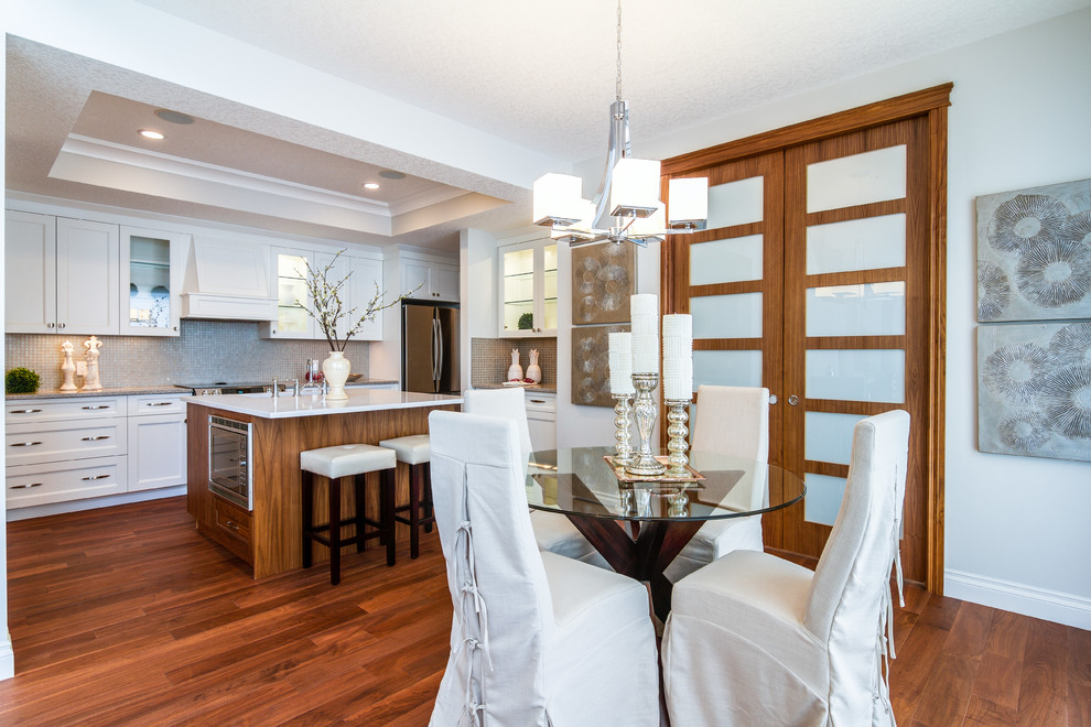This is an example of a large transitional open plan dining in Calgary with medium hardwood floors, white walls and no fireplace.