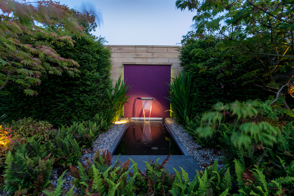 This is an example of a contemporary garden in Cheshire with a water feature.