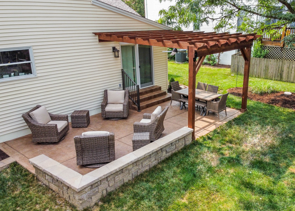 This is an example of a small backyard patio in St Louis with stamped concrete and a pergola.