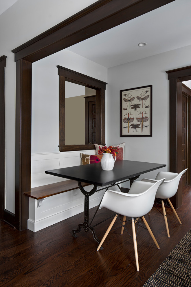 This is an example of a transitional dining room in Detroit with white walls and dark hardwood floors.
