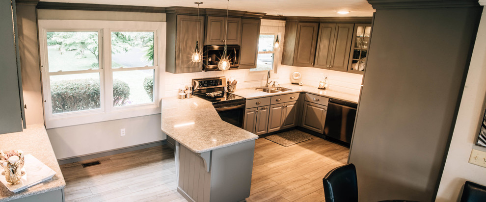 Example of a mid-sized transitional u-shaped medium tone wood floor and brown floor eat-in kitchen design with a double-bowl sink, raised-panel cabinets, gray cabinets, granite countertops, white backsplash, ceramic backsplash, stainless steel appliances, a peninsula and gray countertops