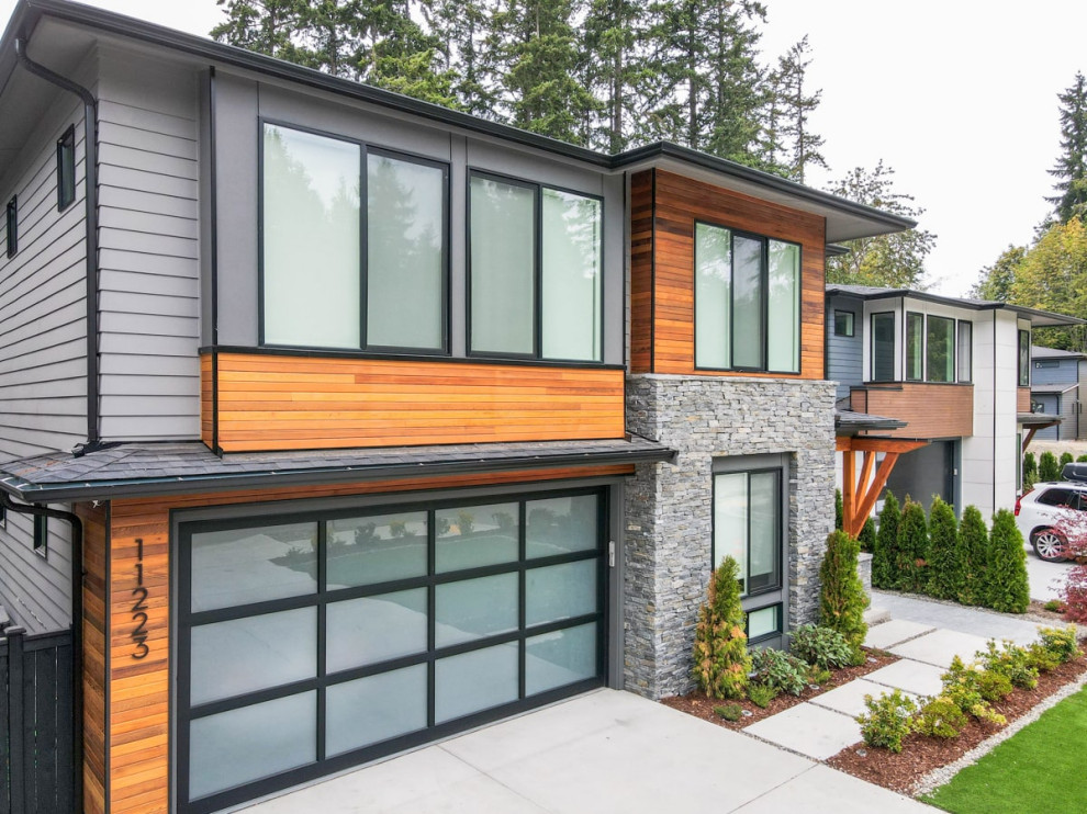 Diseño de fachada de casa pareada gris y negra moderna grande de dos plantas con revestimientos combinados, tejado plano, tejado de metal y panel y listón