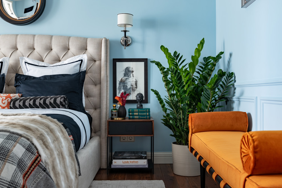 Foto di una camera da letto tradizionale con pareti blu, parquet scuro, pavimento marrone e carta da parati