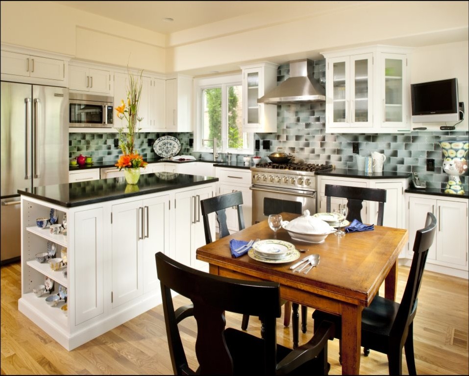 Inspiration for a large transitional l-shaped light wood floor eat-in kitchen remodel in Denver with a farmhouse sink, glass-front cabinets, white cabinets, gray backsplash, glass tile backsplash, stainless steel appliances and an island
