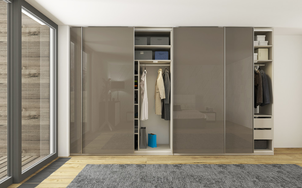 Design ideas for a mid-sized modern built-in wardrobe in New York with flat-panel cabinets and grey cabinets.