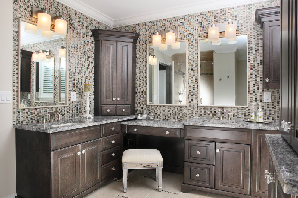 Photo of a mid-sized traditional master bathroom in New York with an undermount sink, raised-panel cabinets, dark wood cabinets, granite benchtops, blue tile and glass tile.