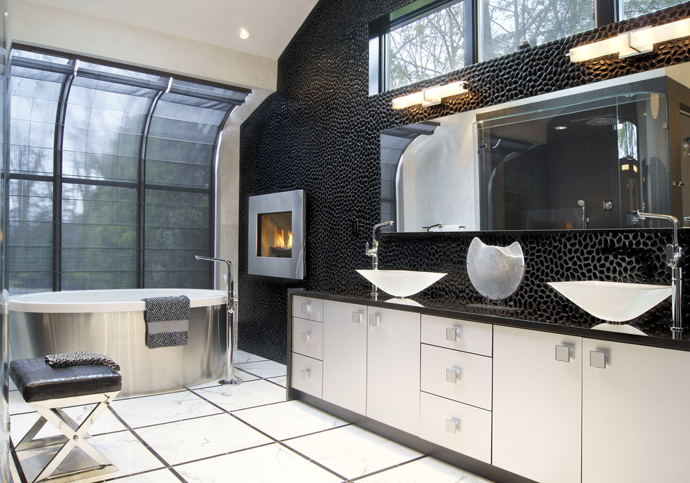 Photo of a modern bathroom in New York with a vessel sink and black walls.