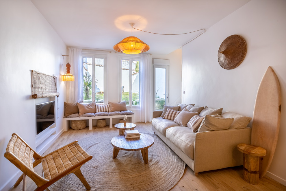 Mediterranean open plan living room in Other with a reading nook, white walls, light hardwood flooring, a concealed tv and feature lighting.