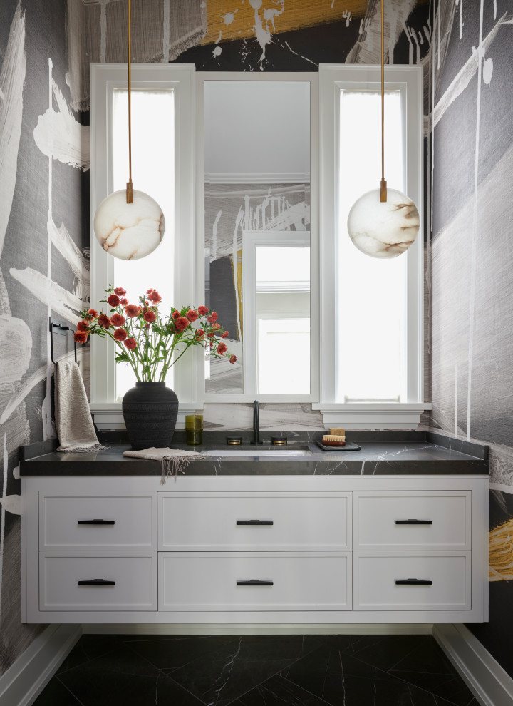 This is an example of a large traditional cloakroom in Toronto with white cabinets, a submerged sink, black floors, black worktops, a floating vanity unit, wallpapered walls, shaker cabinets and multi-coloured walls.