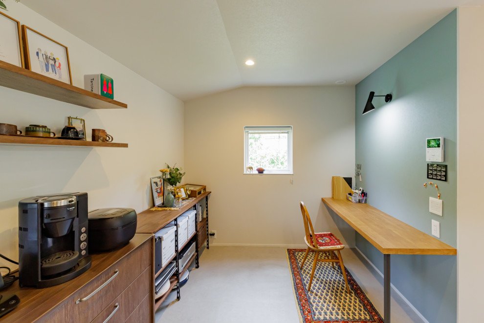 Kleines Skandinavisches Arbeitszimmer ohne Kamin mit Arbeitsplatz, blauer Wandfarbe, Einbau-Schreibtisch, Tapetendecke und Tapetenwänden in Kobe