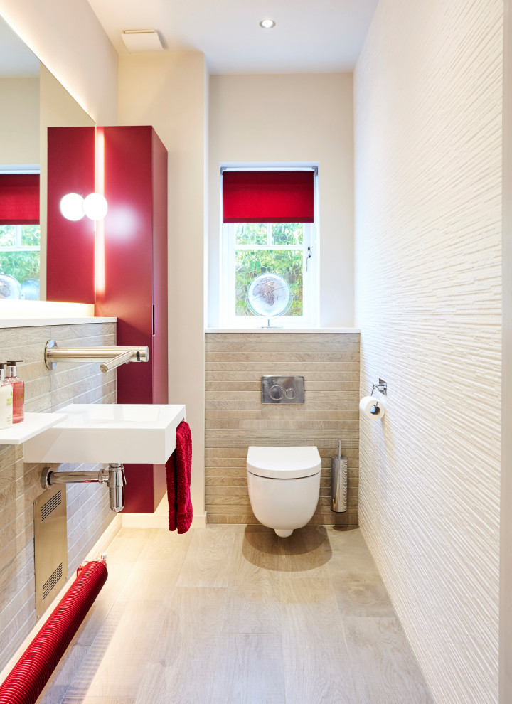 Réalisation d'un petit WC suspendu design avec un placard à porte plane, des portes de placard rouges, un carrelage blanc, des carreaux de porcelaine, un mur gris, un sol en carrelage imitation parquet, un lavabo suspendu, un sol gris et meuble-lavabo suspendu.