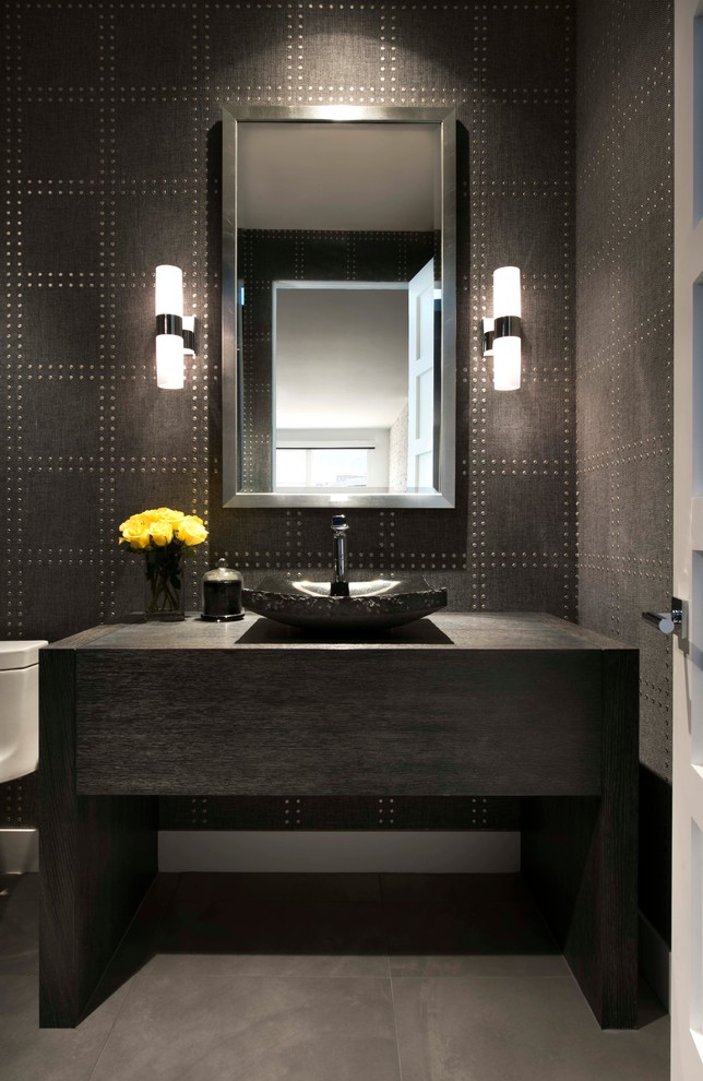 Photo of a small contemporary powder room in Phoenix with furniture-like cabinets, dark wood cabinets, brown tile, brown walls, a vessel sink, wood benchtops and grey floor.