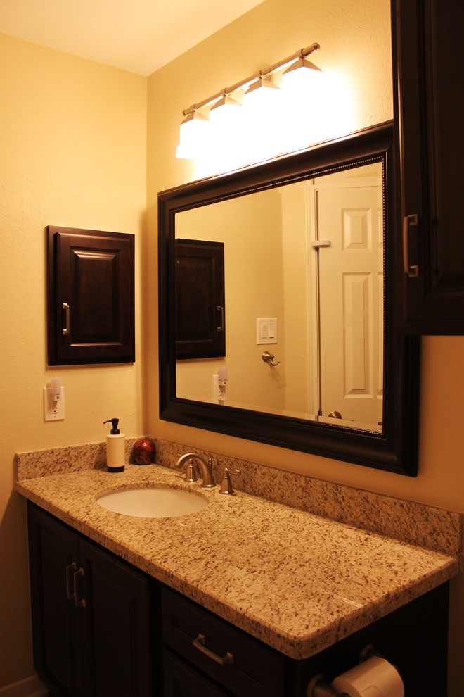 Photo of a mid-sized traditional master bathroom in Houston with an undermount sink, raised-panel cabinets, dark wood cabinets, granite benchtops, a corner shower, a two-piece toilet, beige tile, mosaic tile, beige walls and porcelain floors.