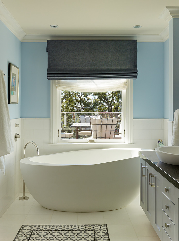 Design ideas for a transitional master bathroom in San Francisco with a vessel sink, blue cabinets, a freestanding tub, white tile and blue walls.