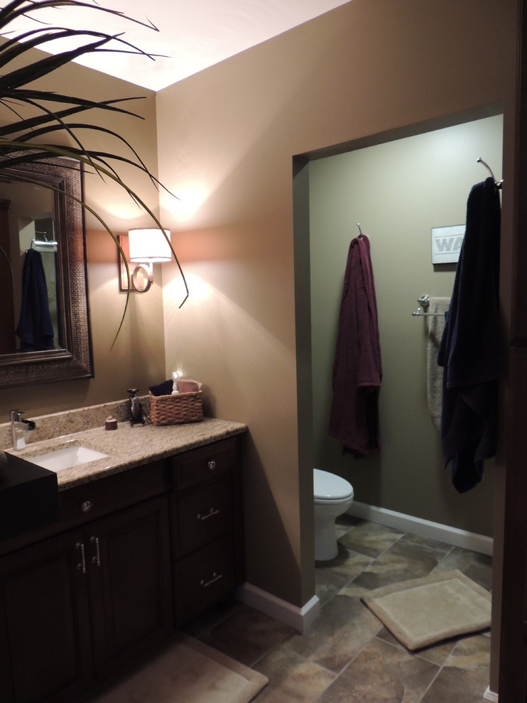Mid-sized traditional 3/4 bathroom in Detroit with raised-panel cabinets, dark wood cabinets, an alcove shower, a two-piece toilet, beige tile, stone tile, beige walls, porcelain floors, an undermount sink and granite benchtops.