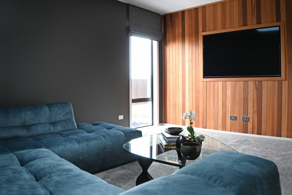 Стильный дизайн: большая изолированная гостиная комната с серыми стенами, ковровым покрытием, мультимедийным центром, серым полом и стенами из вагонки - последний тренд