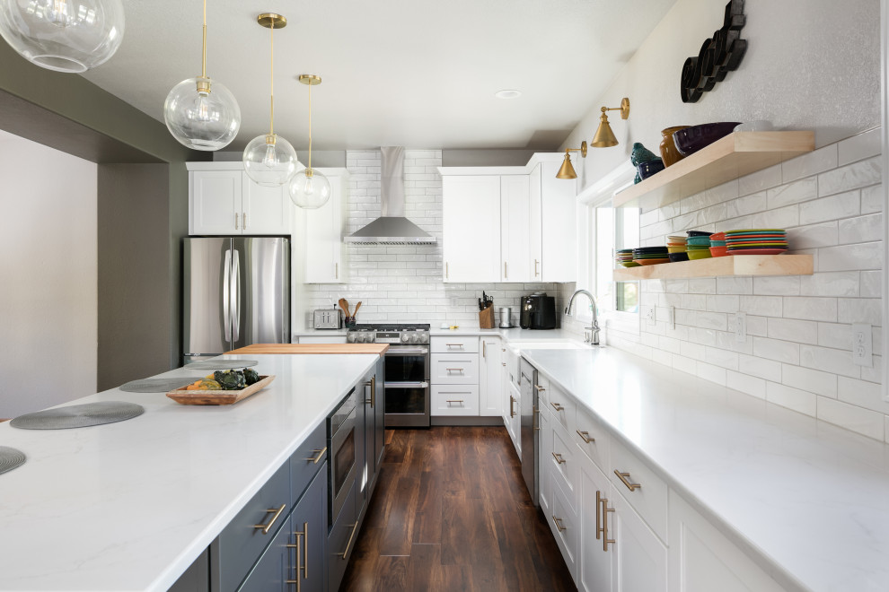 Large transitional u-shaped dark wood floor eat-in kitchen photo in Denver with a farmhouse sink, shaker cabinets, white cabinets, quartz countertops, white backsplash, porcelain backsplash, stainless steel appliances, an island and white countertops