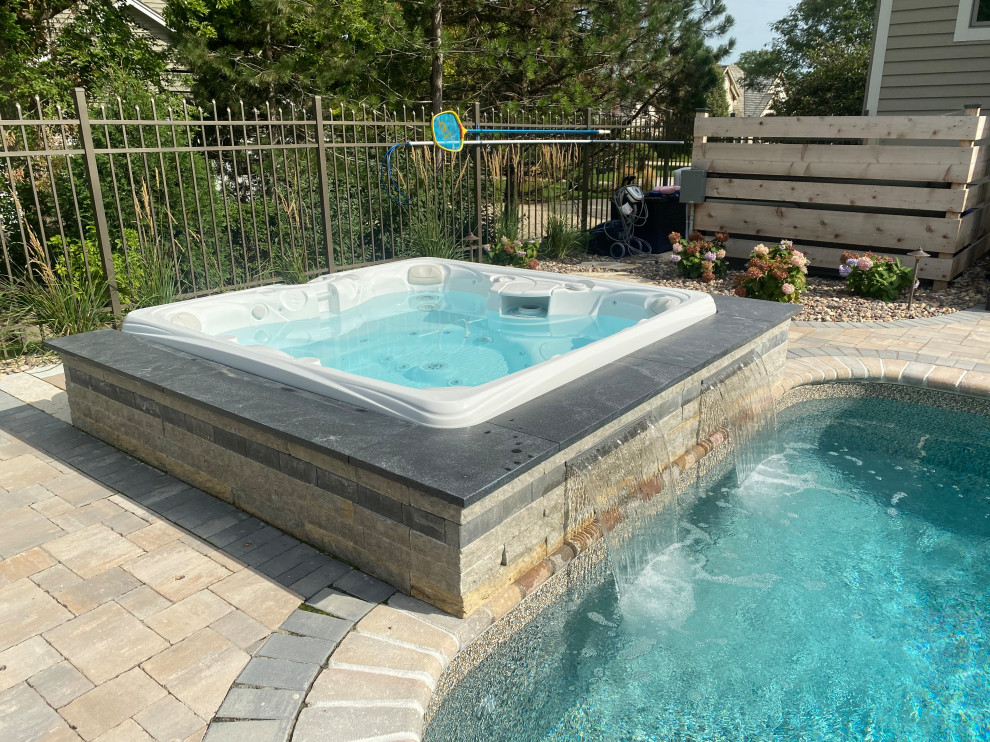 Exempel på en liten eklektisk anpassad pool på baksidan av huset, med spabad och marksten i betong