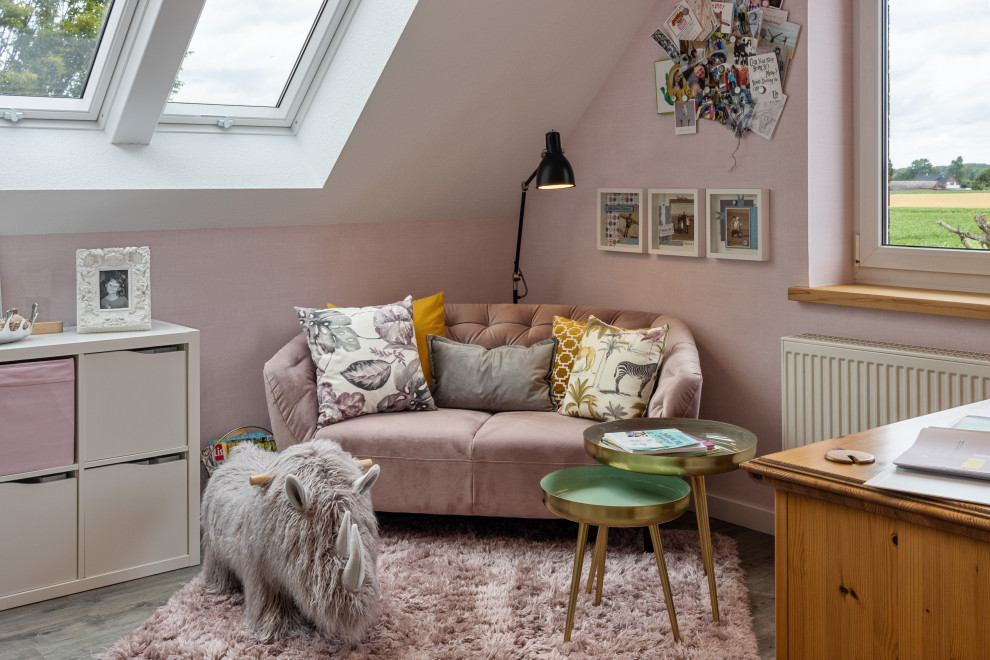 This is an example of a mid-sized contemporary home office in Other with a library, pink walls, vinyl floors, brown floor, wallpaper and wallpaper.