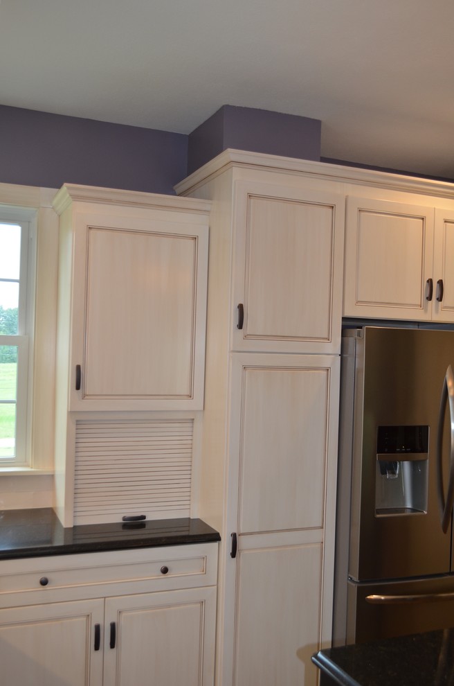 Mid-sized transitional u-shaped brown floor eat-in kitchen photo with a double-bowl sink, recessed-panel cabinets, light wood cabinets, solid surface countertops, white backsplash, stone tile backsplash, stainless steel appliances and an island