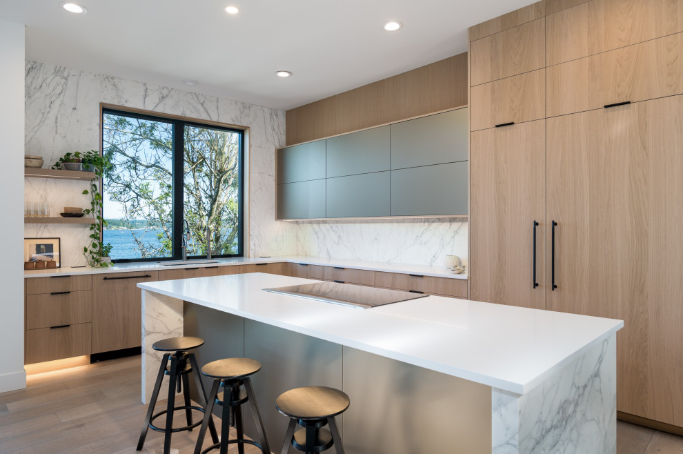 Design ideas for a large contemporary l-shaped open plan kitchen in Phoenix with an undermount sink, flat-panel cabinets, light wood cabinets, quartz benchtops, white splashback, stone slab splashback, panelled appliances, light hardwood floors, with island, brown floor and white benchtop.
