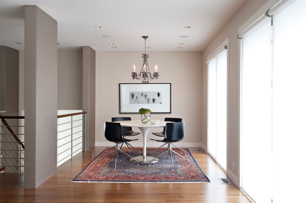 Photo of a modern dining room in Vancouver with beige walls and medium hardwood floors.