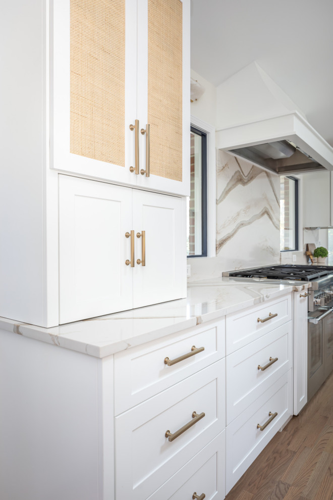 Inspiration for a mid-sized transitional l-shaped open plan kitchen in Raleigh with an undermount sink, shaker cabinets, white cabinets, quartzite benchtops, white splashback, engineered quartz splashback, stainless steel appliances, medium hardwood floors, with island, white floor, white benchtop and vaulted.
