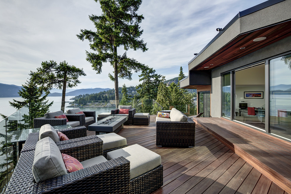 Design ideas for a large country backyard deck in Vancouver with with fireplace and no cover.