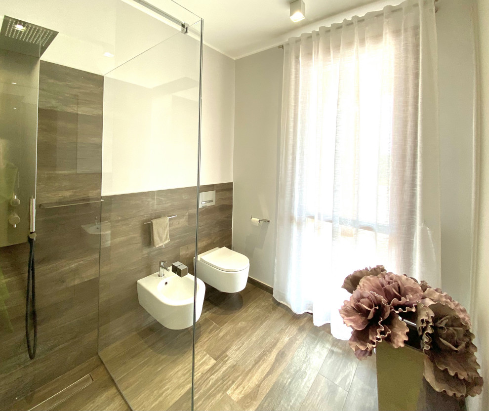 Exempel på ett mellanstort modernt beige beige en-suite badrum, med släta luckor, beige skåp, en kantlös dusch, porslinskakel, grå väggar, klinkergolv i porslin, ett fristående handfat, träbänkskiva och dusch med gångjärnsdörr