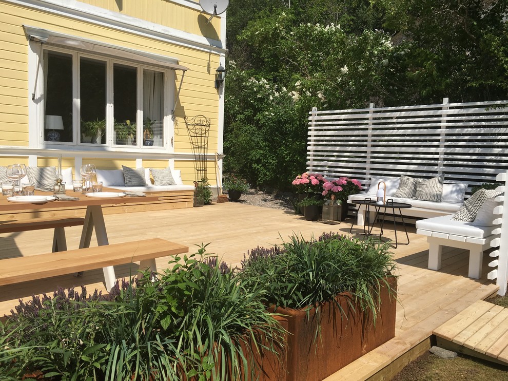 This is an example of a mid-sized traditional backyard deck in Stockholm.