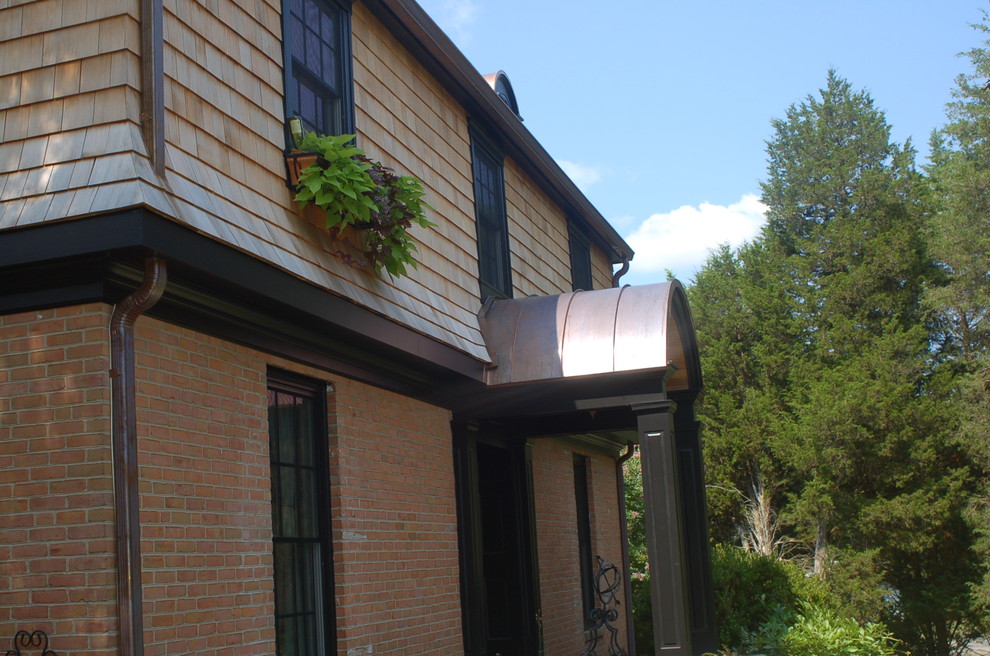 This is an example of a large mediterranean two-storey exterior in DC Metro with wood siding and a gable roof.