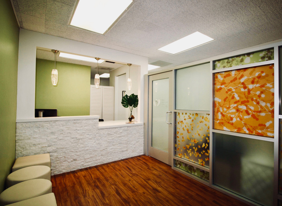 Exemple d'un hall d'entrée tendance de taille moyenne avec un mur vert, un sol en vinyl, une porte simple, une porte marron et un sol marron.