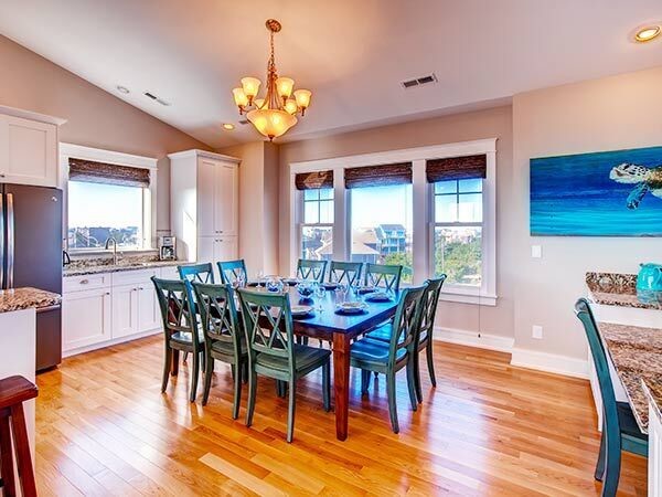 Mid-sized beach style kitchen/dining combo in Other with beige walls, medium hardwood floors and no fireplace.