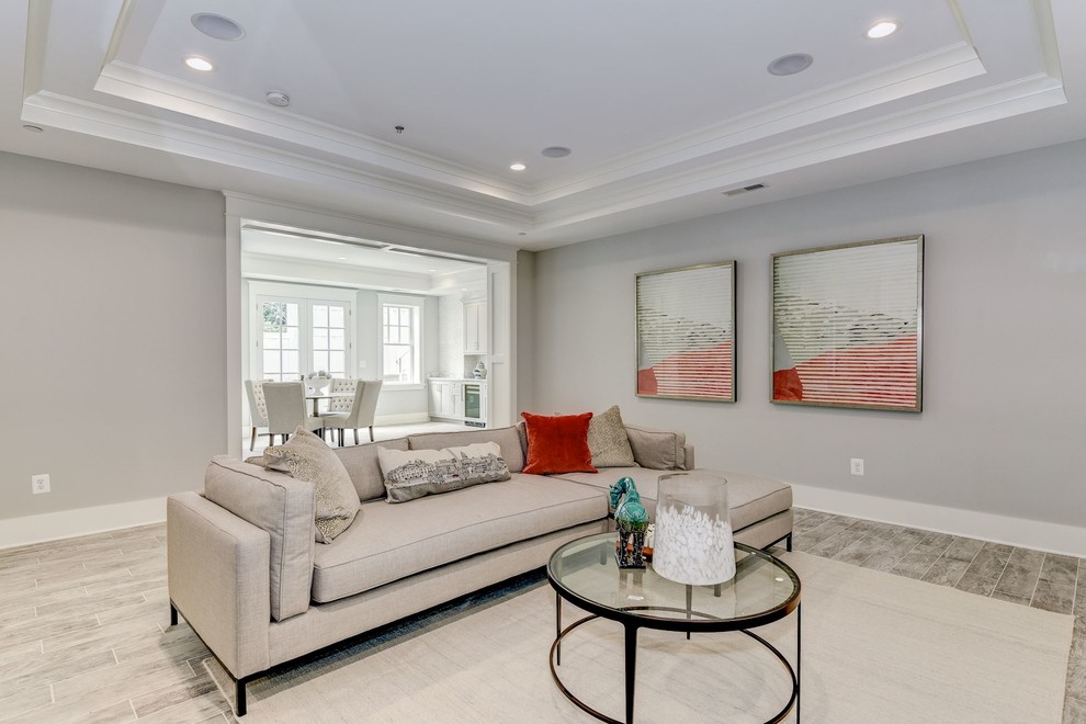 Inspiration for a large arts and crafts walk-out basement in DC Metro with grey walls, ceramic floors, a standard fireplace, a wood fireplace surround and grey floor.