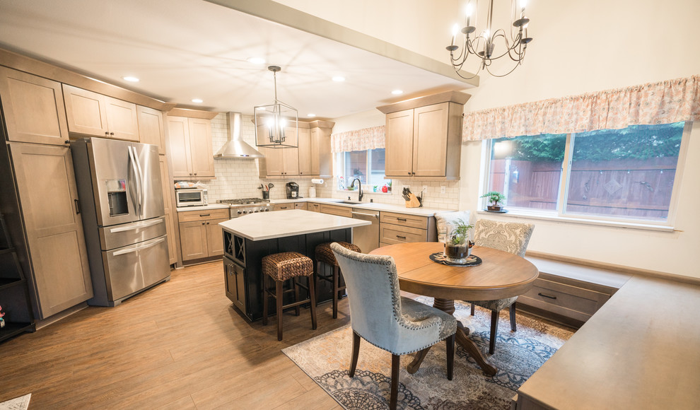 Inspiration for a large transitional l-shaped vinyl floor and brown floor open concept kitchen remodel in Seattle with an undermount sink, recessed-panel cabinets, medium tone wood cabinets, quartz countertops, white backsplash, subway tile backsplash, stainless steel appliances, an island and white countertops