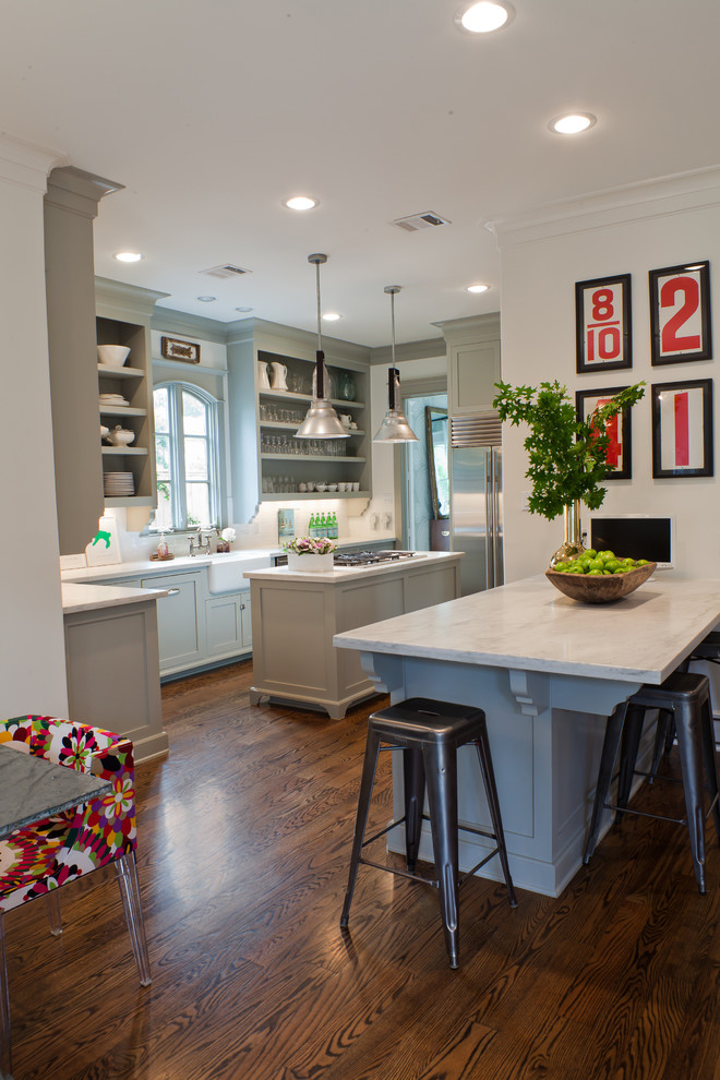 Transitional kitchen in Houston with a farmhouse sink, stainless steel appliances, open cabinets and grey cabinets.