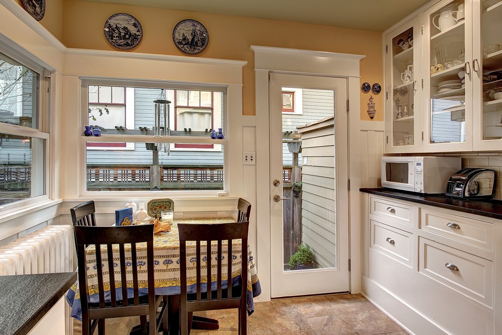 Traditional eat-in kitchen in Seattle with glass-front cabinets and white cabinets.